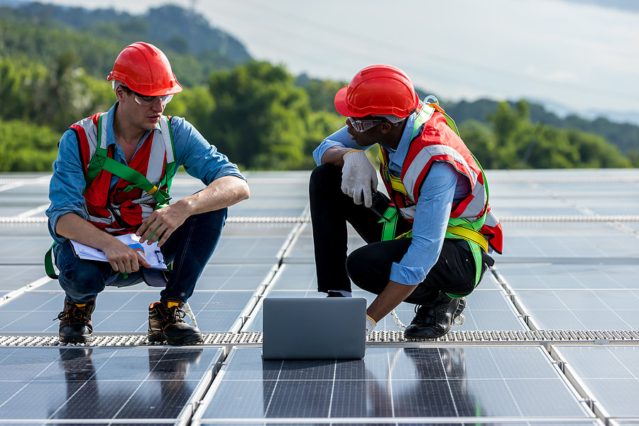 couple of men standing on top of a solar panelPicture