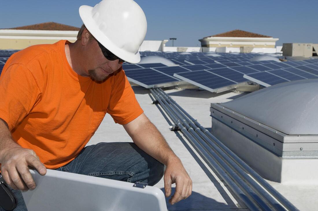 a man working on a roof with solar panelsPicture
