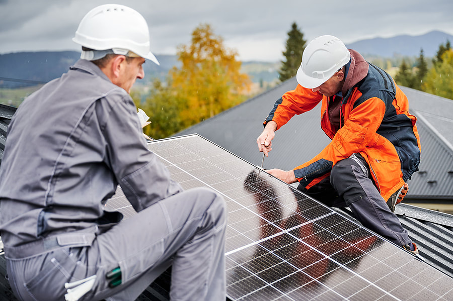 two men on a roof installing a solar panelPicture